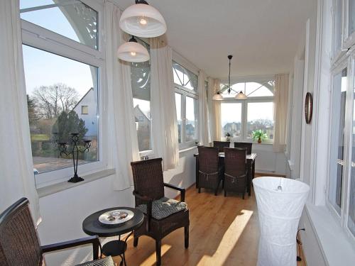 a living room with windows and a table and chairs at Villa Sanssouci - Apt. 02 in Ostseebad Sellin
