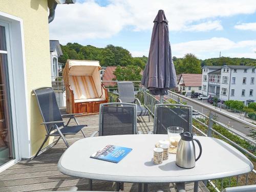 einen Tisch und Stühle auf einem Balkon mit Sonnenschirm in der Unterkunft Villa Sommerwind - WG 01 mit Sauna, Kamin und Terrasse in Ostseebad Sellin