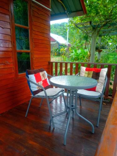einen Tisch und zwei Stühle auf einer Veranda in der Unterkunft The Green Vale B&B in Ban Na Chaliang