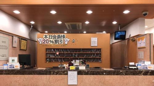 a restaurant with a counter with a wine rack at Toyoko Inn Oyama eki Higashi guchi No 1 in Oyama