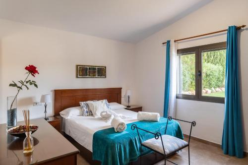 1 dormitorio con cama con sábanas azules y ventana en Villa Can Tomas, en Pollensa