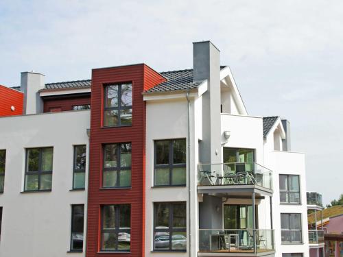 バーベにあるStrandvilla Baabe - Ferienwohnung 16 mit Saunaの赤と白のアパートメントビル