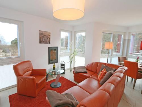 sala de estar con sofá de cuero y sillas en Strandvilla Baabe F 635 WG 26 mit Meerblick, Kamin, Sauna, Whirlpool en Baabe