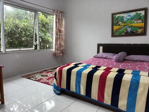 um quarto com uma cama e uma janela em PAPADAAN Homestay Syariah Batu em Karangploso