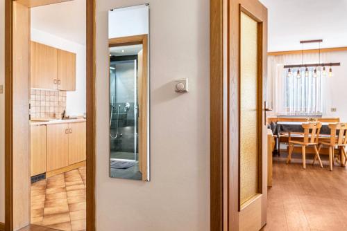 een kamer met een spiegel en een keuken met een tafel bij Villa Erina App A2 in Ortisei