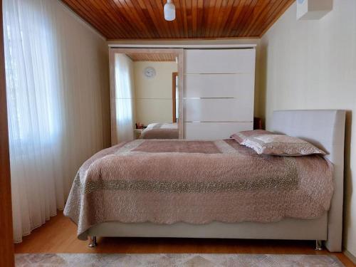 una camera con un grande letto e un soffitto in legno di in the village, with a garden, one floor, detached a Silivri