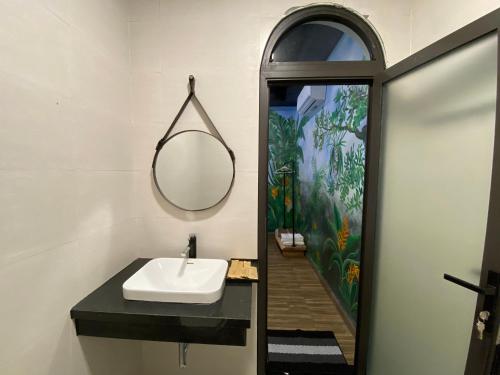 een badkamer met een wastafel en een spiegel bij Cerf Volant Soc Son in Hanoi