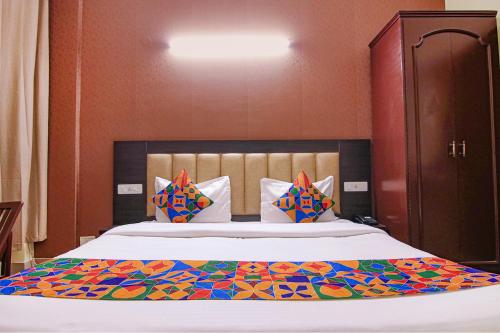 a bedroom with a large bed with a colorful blanket at FabHotel Town Pride in Sohāna