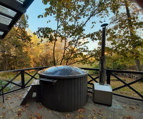 a large trash can sitting on a patio next to a fence at Mošķu Pirts meža māja in Turaida