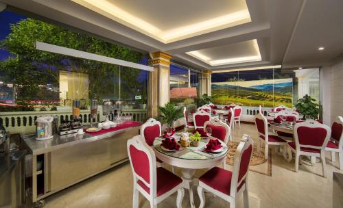 una sala da pranzo con tavolo, sedie rosse e tavolo di Sapa Praha Hotel a Sa Pa