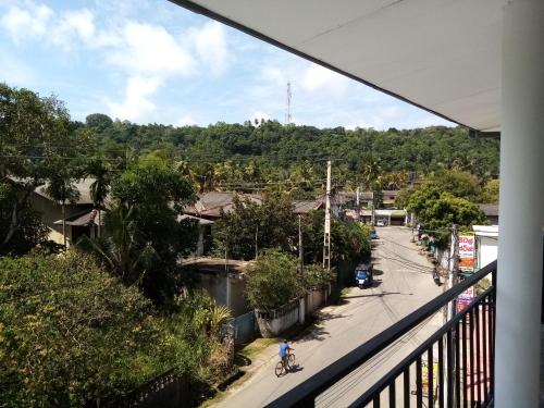 a person riding a bike down a city street at Senethaya Apartment in Unawatuna