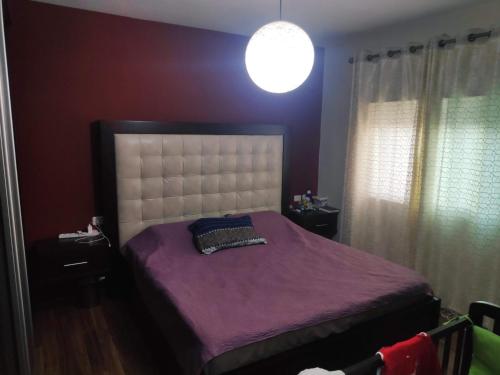 a bedroom with a bed with purple sheets and a lamp at Fully Furnished Apartment in Bethlehem Center in Bethlehem
