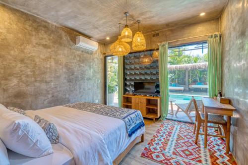 a bedroom with a bed and a desk and a table at Leafy Home Canggu in Canggu