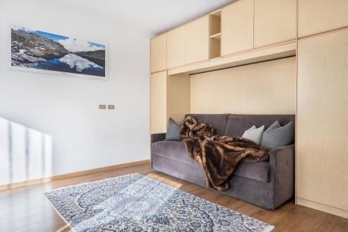 a living room with a gray couch and a rug at Villa Erina App D in Ortisei