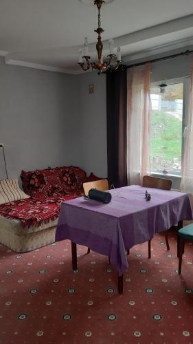 a room with a purple table and a bed at Садиба в Бабаєво in Perechin