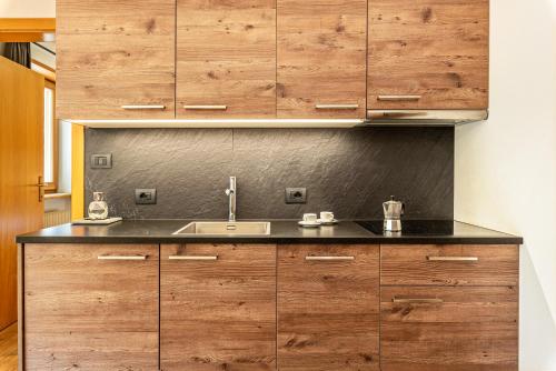 eine Küche mit Holzschränken und einem Waschbecken in der Unterkunft Villa Erina App C3 in St. Ulrich in Gröden