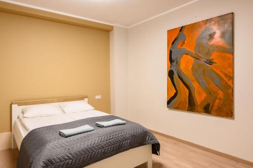 a bedroom with a bed and a painting on the wall at Kastanimaja Apartments in Tartu
