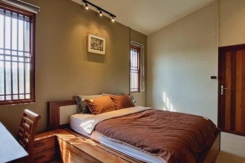a bedroom with a bed in a room with windows at InnerZen Riverside homestay Ben Tre - Japanese style in Ấp Phú Hòa (3)