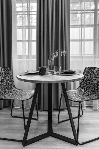 a table and two chairs in front of a window at Kastanimaja Apartments in Tartu