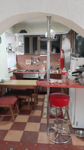 a kitchen with a red counter and a red stool at Садиба в Бабаєво in Perechin