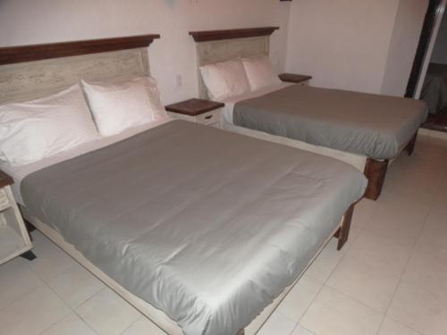 two beds in a hotel room with two bedsvisor at Cuarto Casa Alebrije in Valle de Bravo