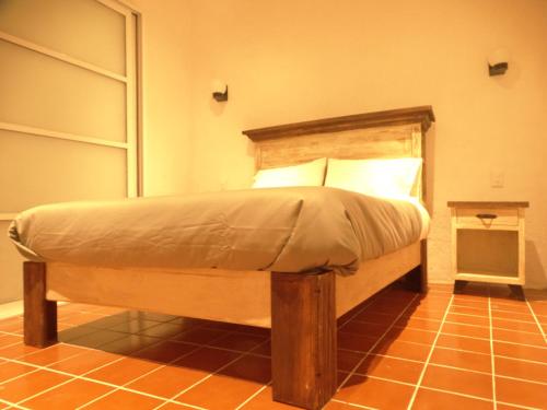 a bed with a wooden headboard in a room at Cuarto Casa Alebrije in Valle de Bravo