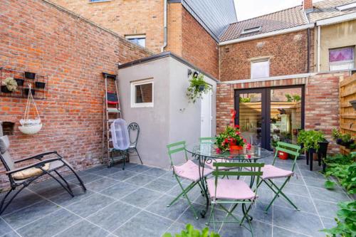 a patio with a table and chairs and a brick building at Nadia B&B in Nivelles