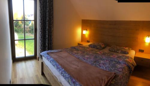 ein Schlafzimmer mit einem Bett und einem großen Fenster in der Unterkunft Mountain chalet in Kořenov