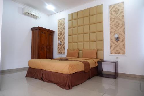 a bedroom with a large bed with a large headboard at Griya Limasan Gunung Kidul in Wonosari