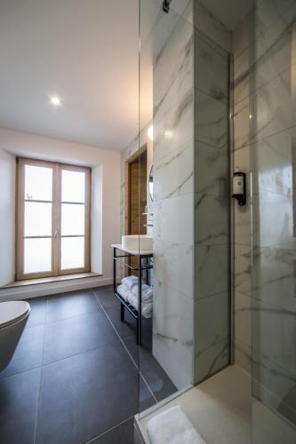 une salle de bain avec une douche en verre et un lavabo dans l'établissement Best Western Le Relais du Vigneron, à Vertus