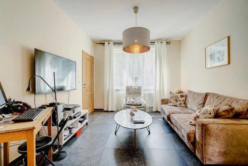 uma sala de estar com um sofá e uma mesa em Nadia B&B em Nivelles