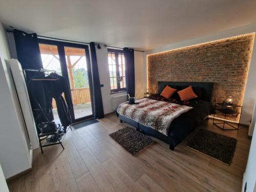 1 dormitorio con cama y pared de ladrillo en Suite Tino, en Verviers