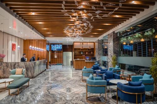 a lobby with blue chairs and a bar at Lords Inn Rajkot in Rajkot