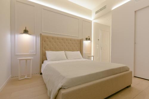 a white bedroom with a large bed and two tables at Amendola Central Station in Bologna