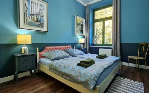 Dormitorio azul con cama y ventana en Art-House Kurort Rathen en Kurort Rathen