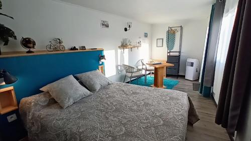 1 dormitorio con cama y pared azul en Le Clos des Passiflores - B&B, en Pons