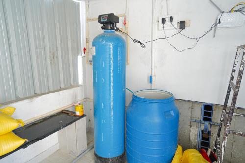 a blue water tank in a room with a bucket at MAHASRI Studio Apartments- Brand New Fully Furnished Air Conditioned Studio Apartments in Tirupati