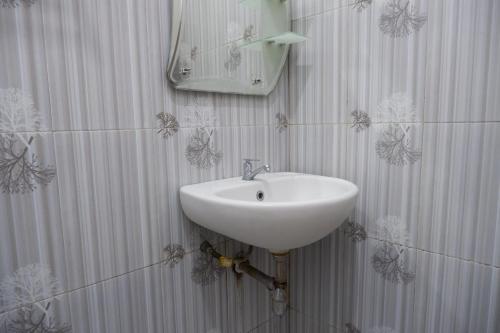 a bathroom with a sink and a mirror on the wall at Griya Limasan Gunung Kidul in Wonosari