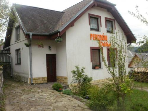 une maison blanche avec un panneau sur son côté dans l'établissement Penzión Dúha, à Dedinky