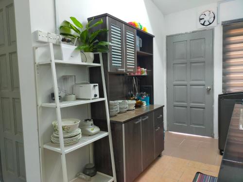 a kitchen with a shelf with dishes on it at D'Port DicksonMuslimOnly Homestay in Port Dickson