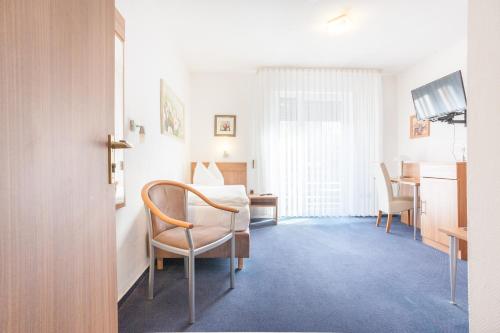 Cette chambre comprend un lit, une table et des chaises. dans l'établissement TM Hotel Dortmund Airport, à Holzwickede