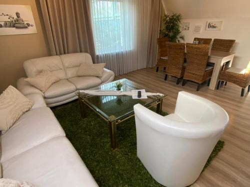 a living room with a white couch and a table at Wilsmann Apartmentvermietung in Hövelhof