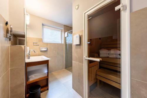 a bathroom with a shower and a sink at der Sonnberg Alpinlodges - Apartments mit Seeblick, privater Sauna und Self Check-In in Zell am See
