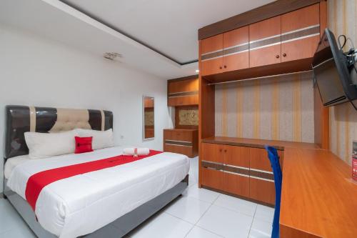 una camera con letto e TV a schermo piatto di RedDoorz near RSIA Andini Pekanbaru a Pekanbaru