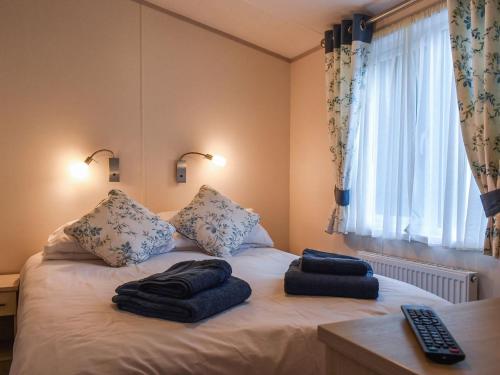 a bedroom with a bed with two towels on it at Elm Lodge in Ilfracombe