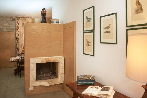 a living room with a fireplace and a table with a lamp at I Casaloni in Panzano