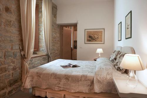 1 dormitorio con cama y pared de ladrillo en I Casaloni, en Panzano