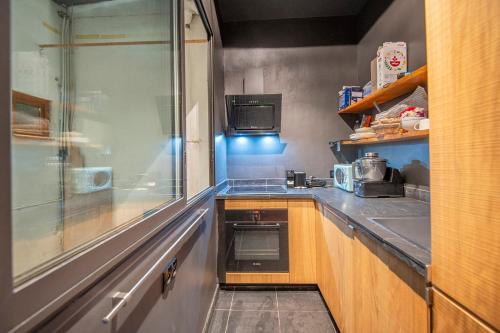 une petite cuisine avec un évier et une cuisinière dans l'établissement 80m with garden view near the Old Port, à Marseille