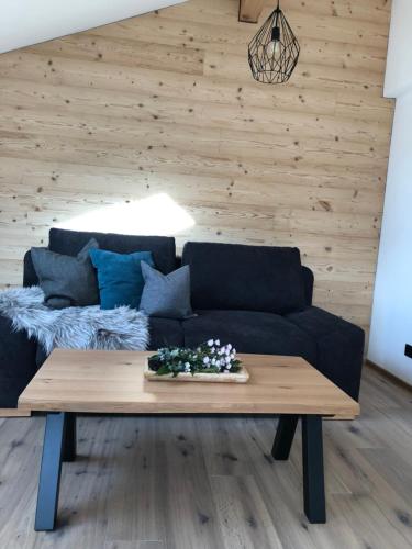 a living room with a blue couch and a wooden table at Ferienwohnung Familie Zint in Sonthofen