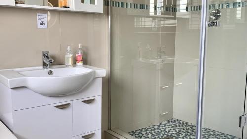 Cape Town的住宿－Modern apartment with stunning Sea Views，白色的浴室设有水槽和淋浴。